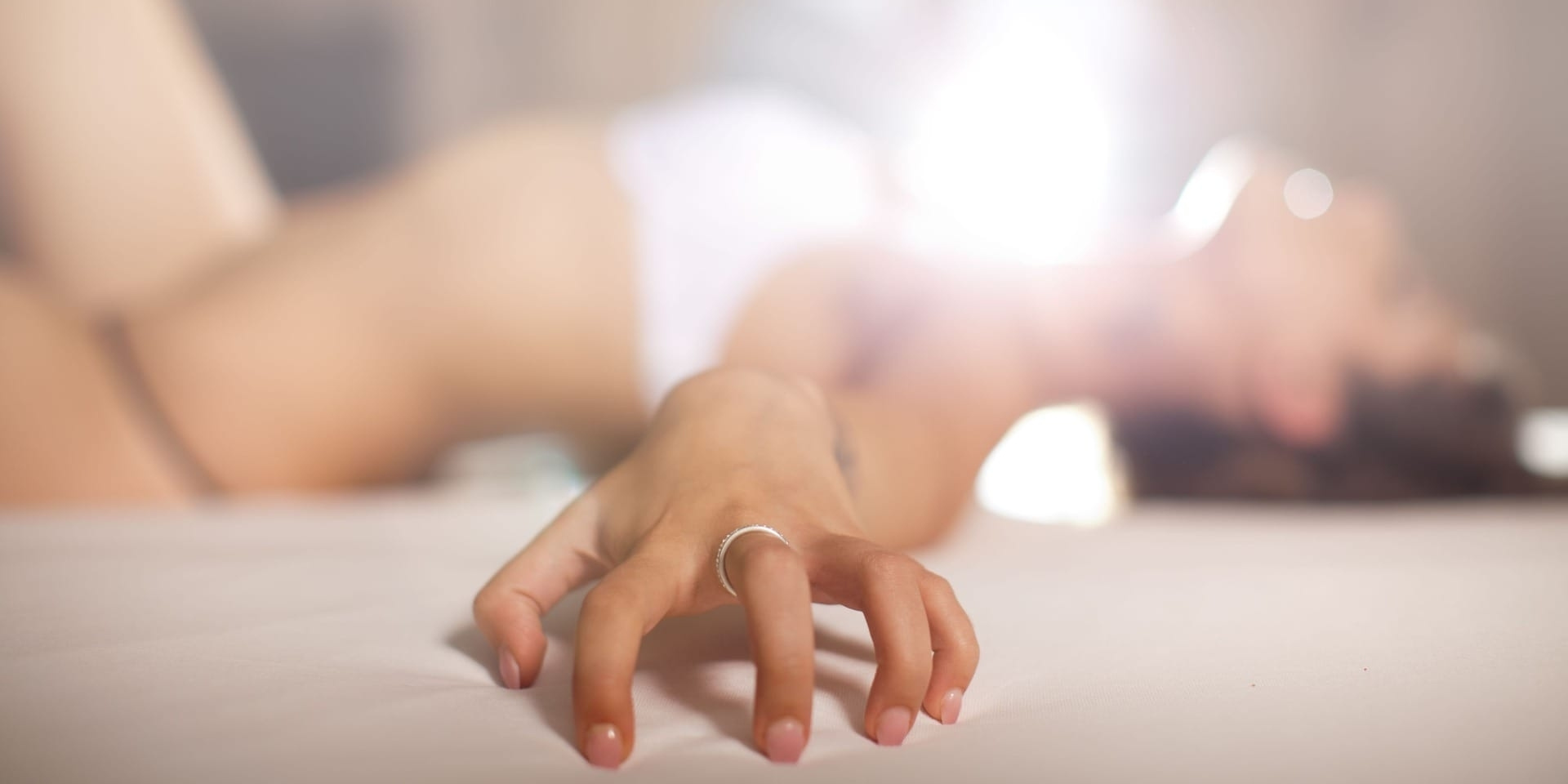 Woman relaxing in bed during intimate self-care – clitoral stimulant guide