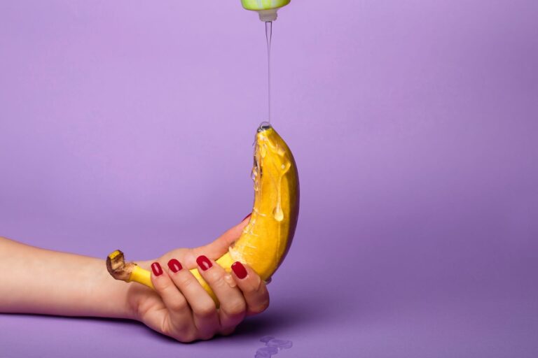 Banana held against a purple background, used as a visual metaphor in an article about lube alternatives.