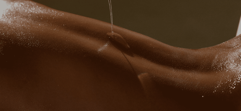 Golden oil being gently poured onto smooth, hydrated skin, highlighting moisture and relaxation