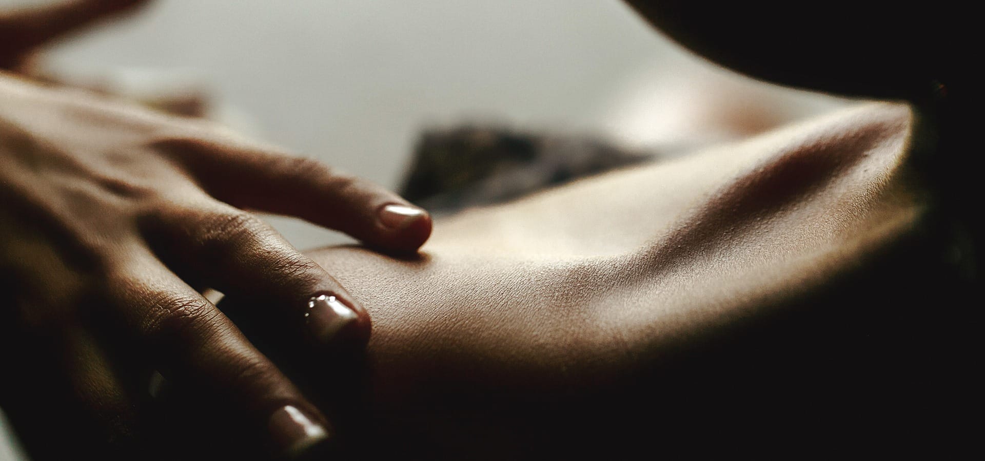 Body oil being applied to skin as part of a self-care ritual