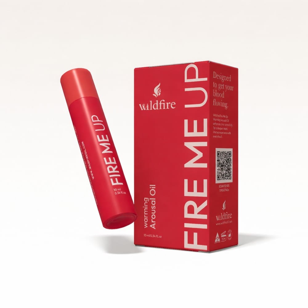 Fire Me Up warming arousal oil by Wildfire with product packaging on a clean background