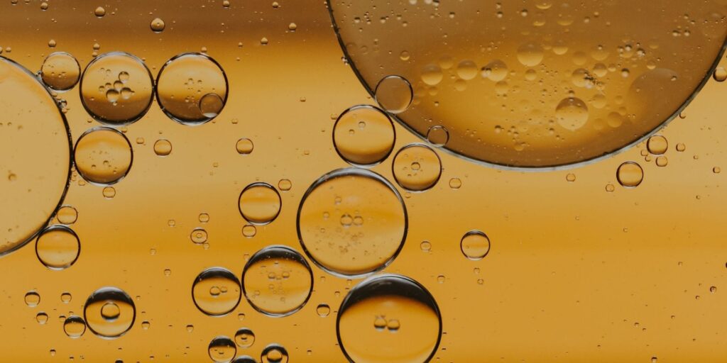 Natural body oil with essential oils suspended, illustrating aromatherapy and skin nourishment