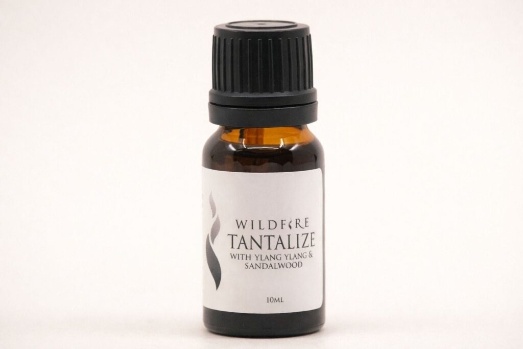 Wildfire Tantalize sensual essential oil with ylang ylang and sandalwood on a soft neutral background