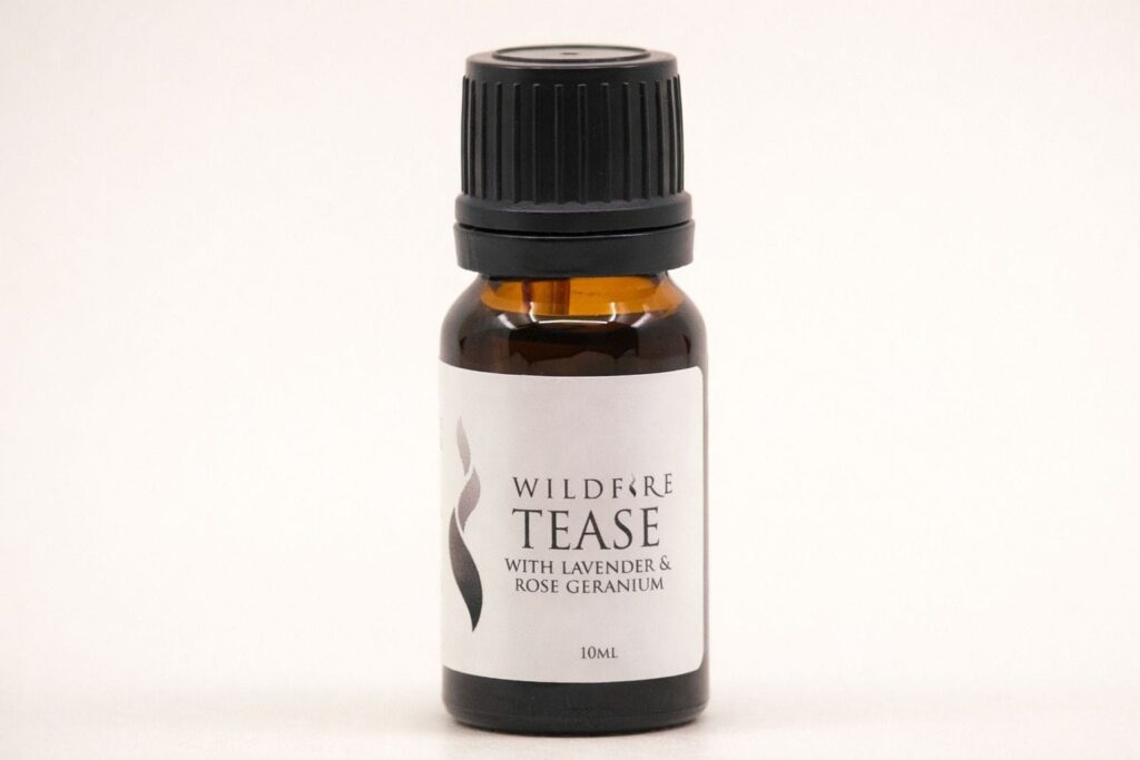 Wildfire Tease romantic aphrodisiac essential oil with lavender and rose geranium in a calm neutral studio setting