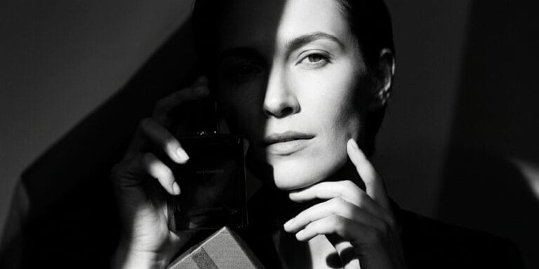 Woman holding perfume while choosing the best perfume to give as a gift