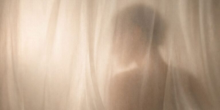 Abstract editorial image representing scent and memory through soft light and a blurred human silhouette, evoking intimacy, familiarity, and emotional presence.